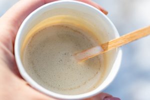 Hand holding paper cup of coffee